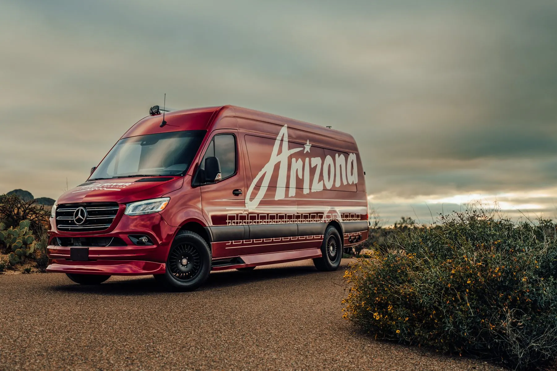 Custom wrapped van, front three quarter at dusk, the Arizona script along the side