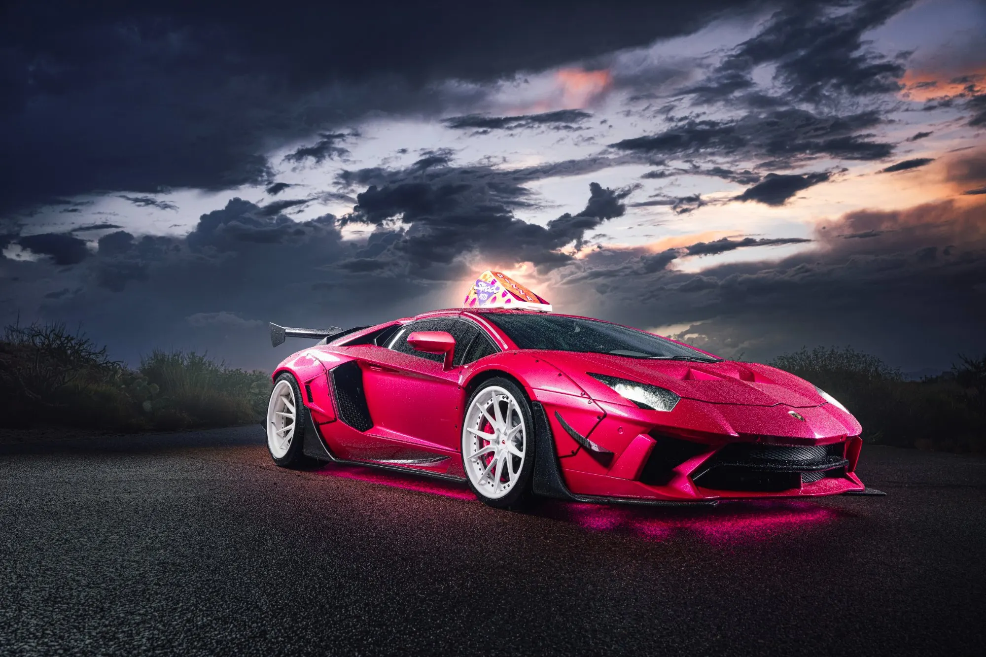 Magenta supercar from the front three quarter under a broken dusk sky