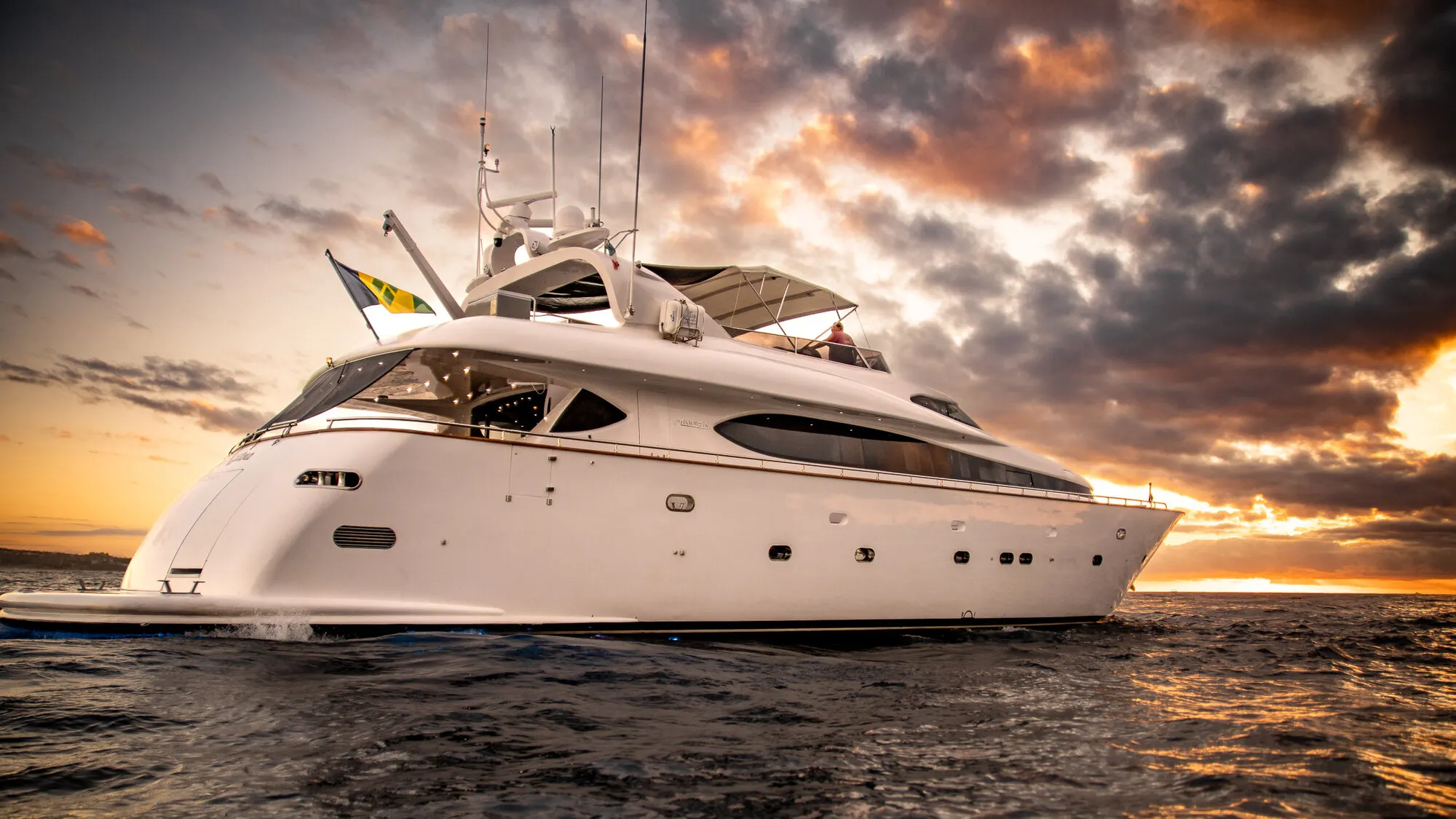From the bow quarter with the sunset behind the flybridge